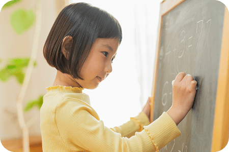 黒板に板書している女の子